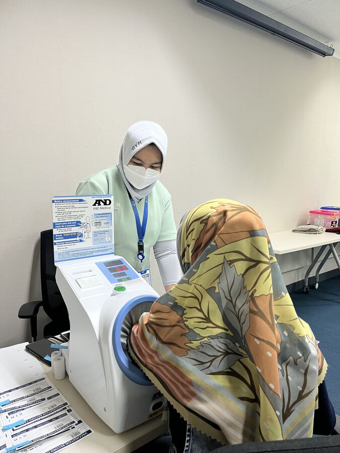 Perawat DYM Medical Clinic melakukan skrining tekanan darah karyawan sebelum vaksinasi influenza onsite