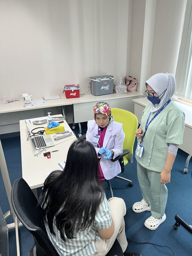 Dokter DYM Medical Clinic melakukan konsultasi dengan karyawan sebelum vaksinasi influenza di ruang meeting kantor